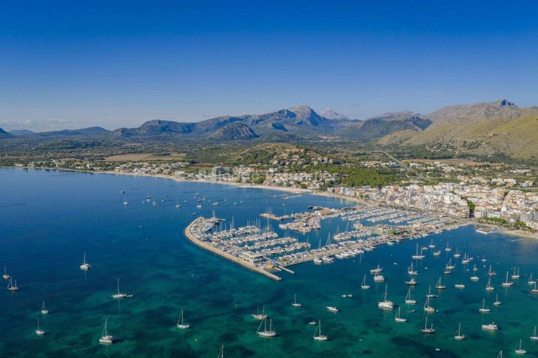 Vista aérea de la playa, el puerto deportivo y la Serra de Tramuntana en Puerto Pollensa, Mallorca.